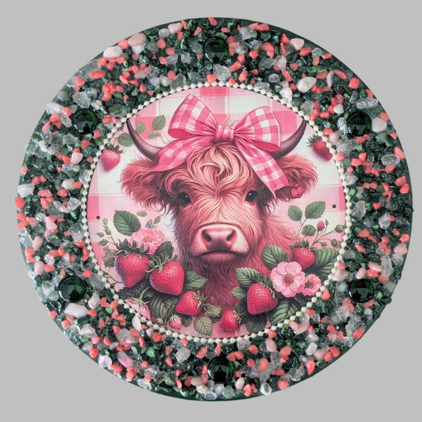 "Strawberry Fields and Tartan Bows" is a handmade canvas featuring a print of a cow with a red tartan bow, surrounded by strawberries and decorated with green stones and green, red, pink & clear stones & pebbles.