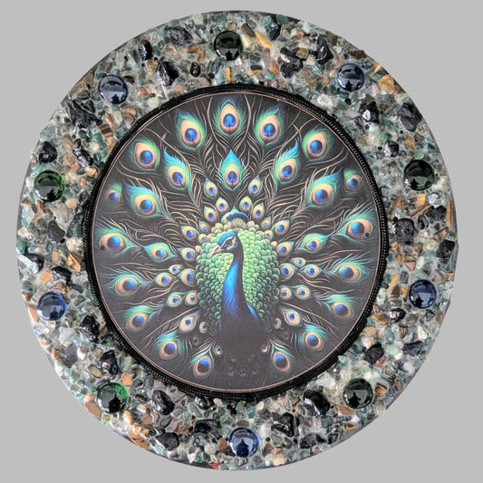 "A Lyrebird's Dance" is a handmade canvas featuring a print of a vibrant lyrebird framed by green, black, blue, and earthy stones, symbolising natural harmony.