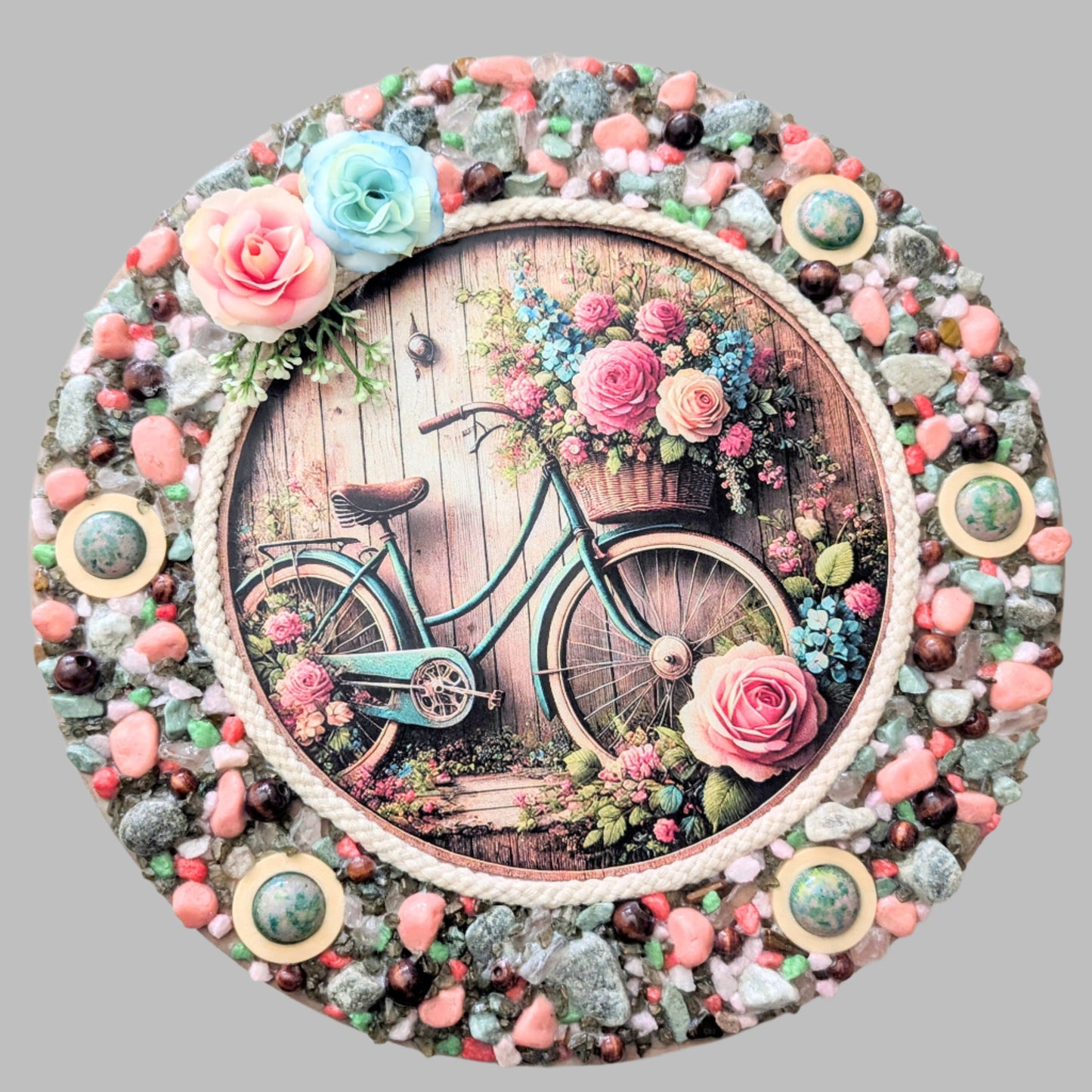 A canvas featuring a print of a vintage aqua bike with floral accents, blending nature's beauty and nostalgia, decorated with pebbles and stones.