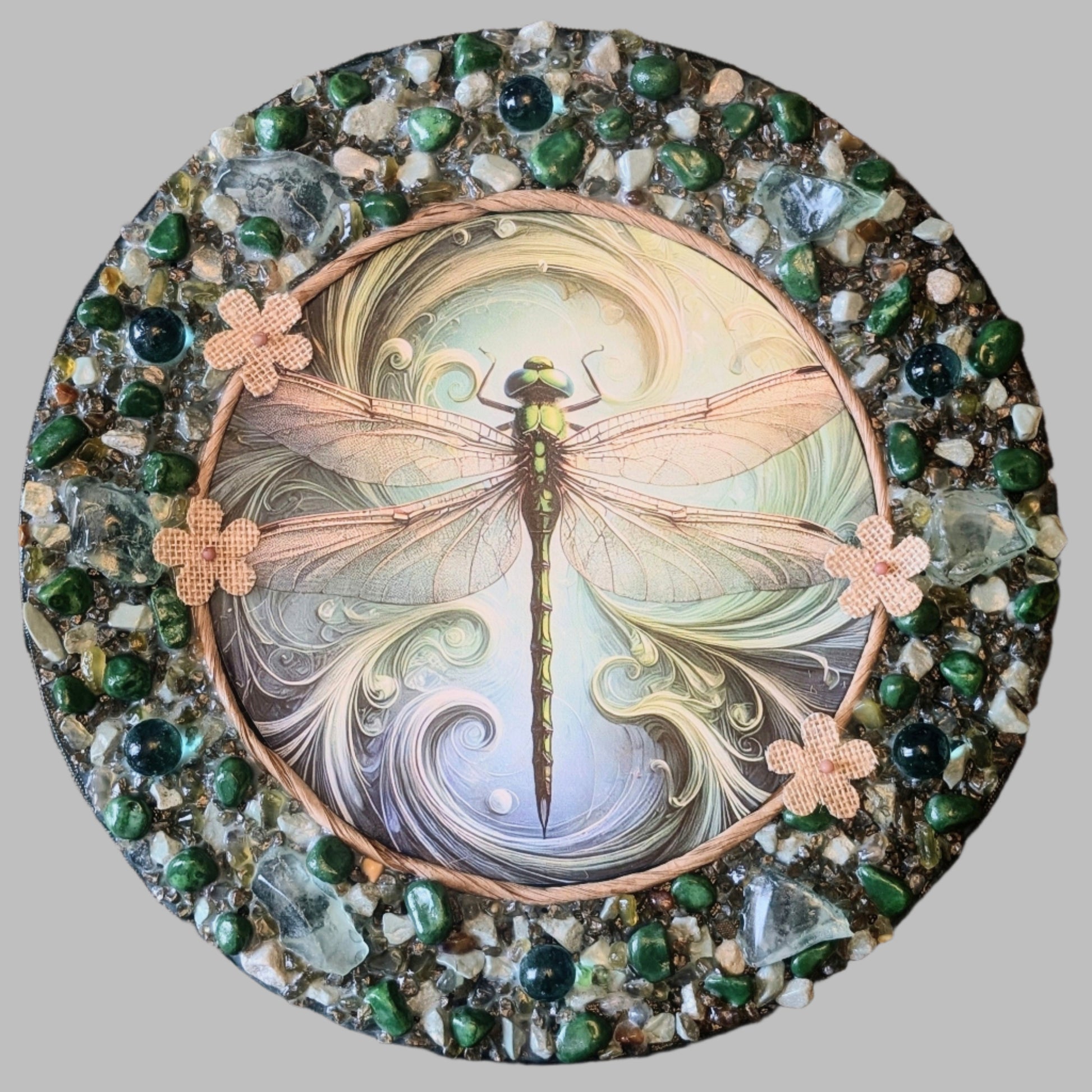 "Ethereal Flight" is a handmade canvas featuring a print of a dragonfly in motion, decorated by earthy stones and delicate rattan accents.