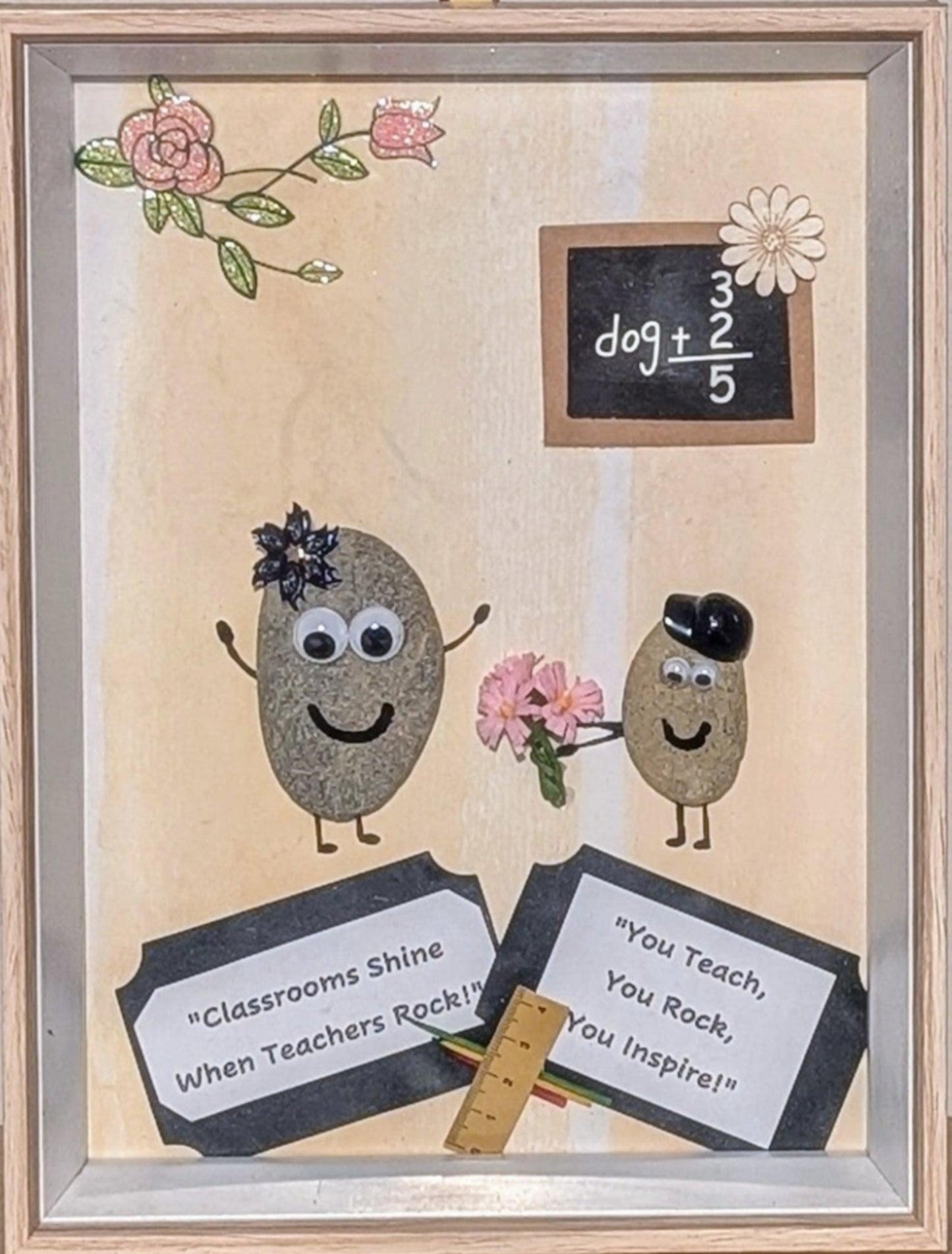 Framed pebble art of a teacher receiving a bouquet of flowers from a student, with a blackboard and school tools, celebrating the bond and appreciation in education.