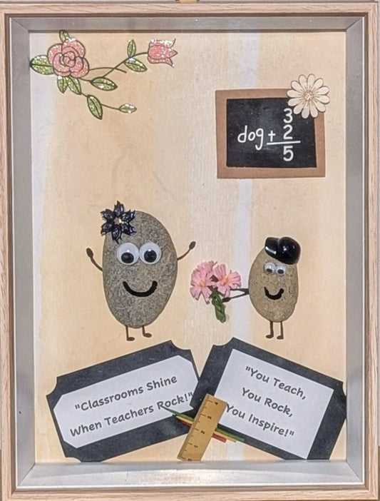 Framed pebble art of a teacher receiving a bouquet of flowers from a student, with a blackboard and school tools, celebrating the bond and appreciation in education.