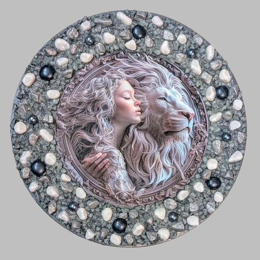 "The Lion’s Embrace" is a handmade canvas with a print of a white lion and woman, decorated with white and grey stones and pebbles, symbolising strength, unity, and nature's beauty.